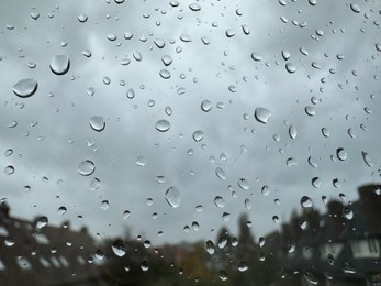 Photo of Window with water droplets on rainy day, closeup