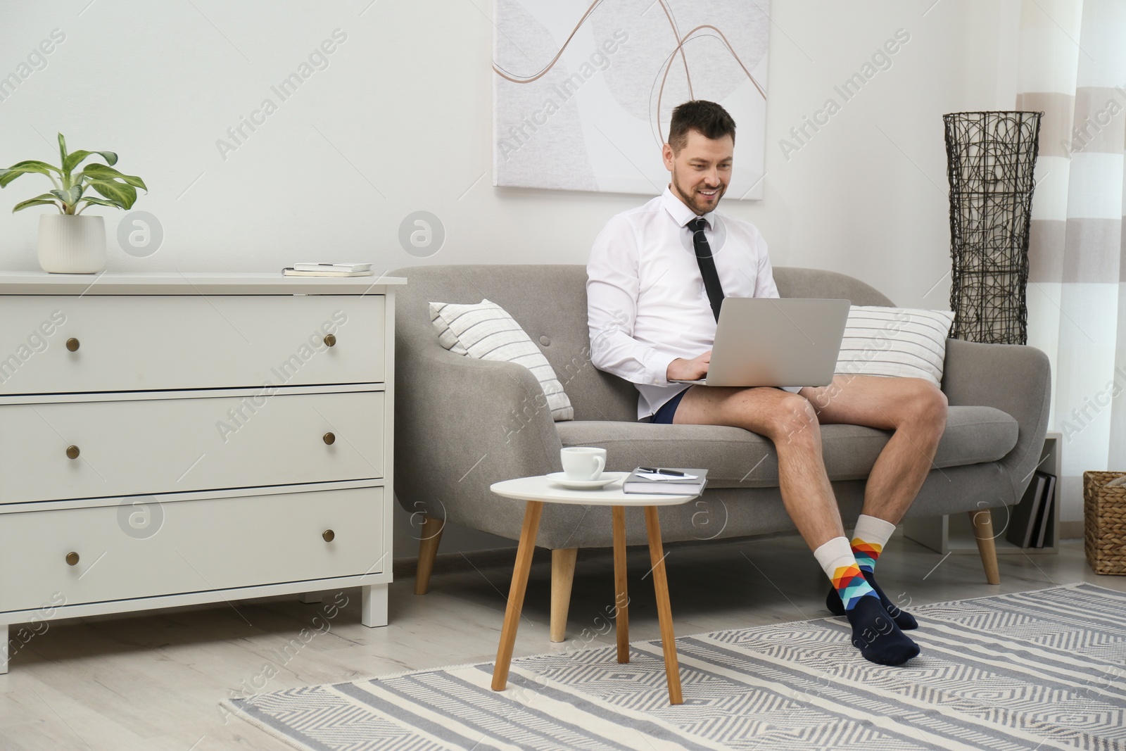 Photo of Businessman wearing shirt and underwear during video call at home