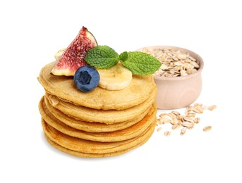 Tasty oatmeal pancakes and ingredients on white background