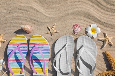 Photo of Flat lay composition with flip flops on sand. Beach accessories for summer vacation