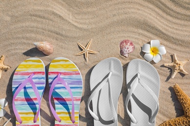 Flat lay composition with flip flops on sand. Beach accessories for summer vacation