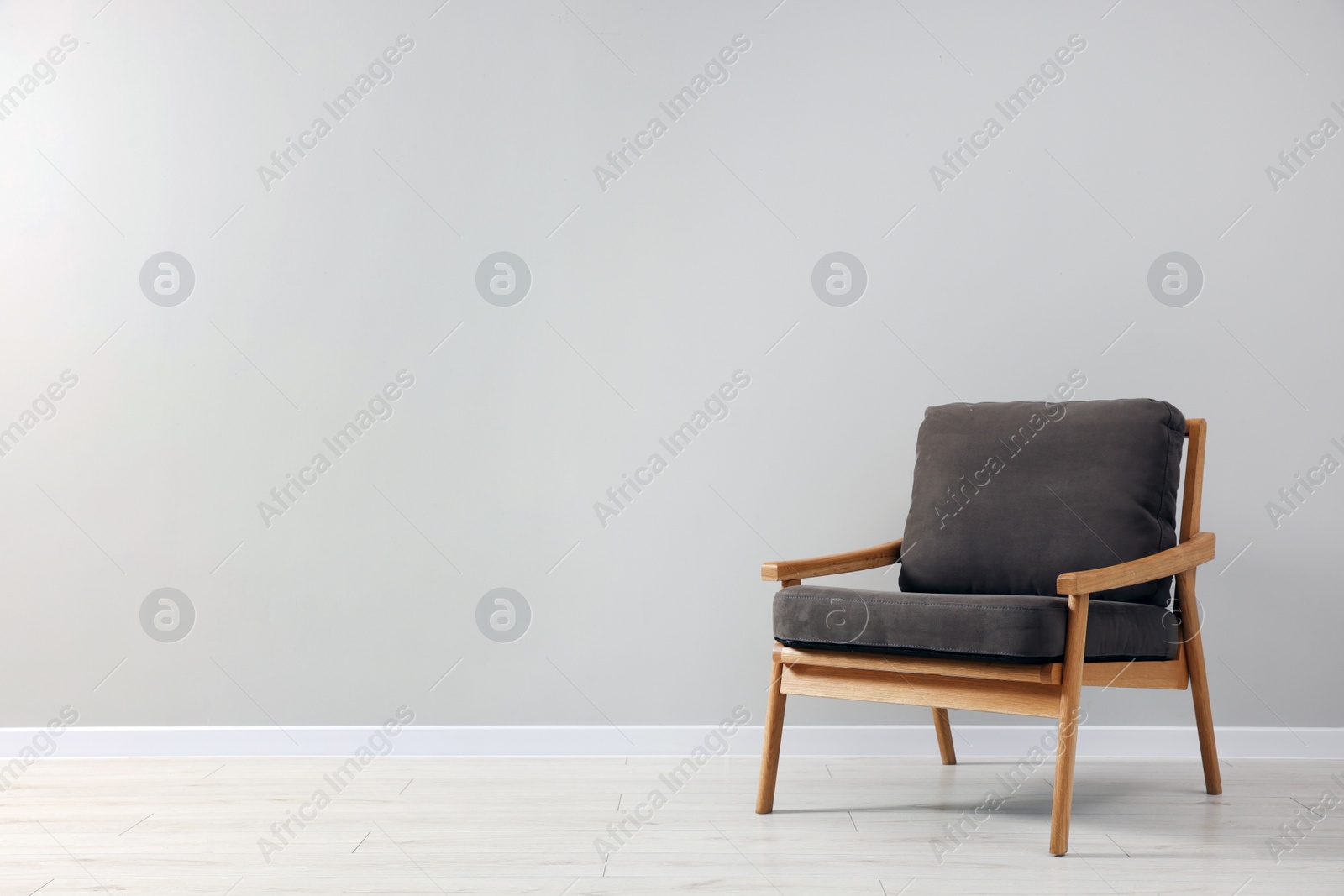 Photo of Comfortable armchair near light grey wall indoors. Space for text