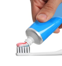 Photo of Man applying toothpaste on brush against white background, closeup