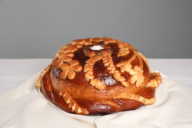 Korovai on tablecloth against grey background. Ukrainian bread and salt welcoming tradition