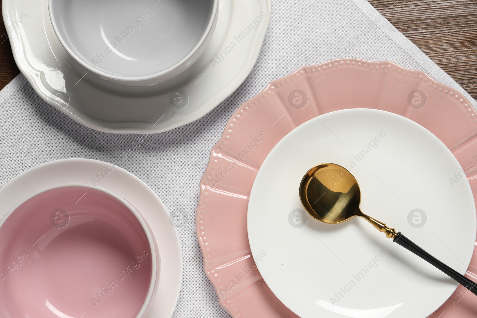 Photo of Beautiful ceramic dishware and spoon on wooden table, top view