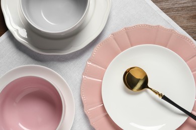 Beautiful ceramic dishware and spoon on wooden table, top view