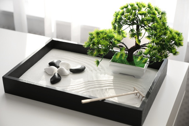 Photo of Beautiful miniature zen garden on white table indoors