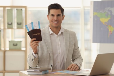 Travel agent with tickets and passports in office