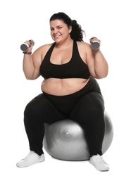 Photo of Overweight woman doing exercise on fit ball with dumbbells against white background