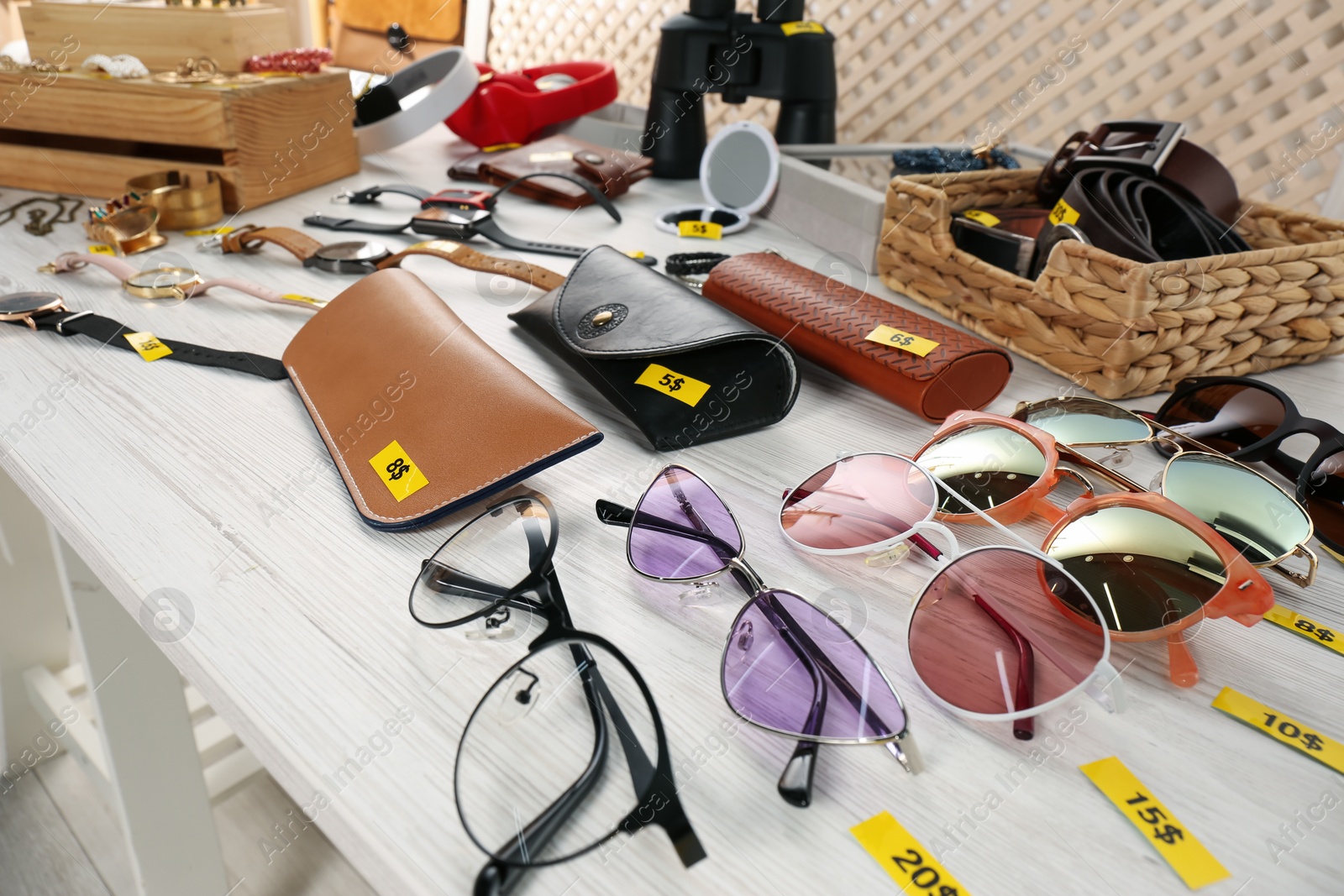 Photo of Many different items on white wooden table indoors. Garage sale