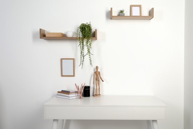 Photo of Comfortable workplace with white desk near wall at home