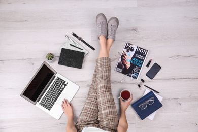 Photo of Fashion blogger with laptop sitting on floor, top view