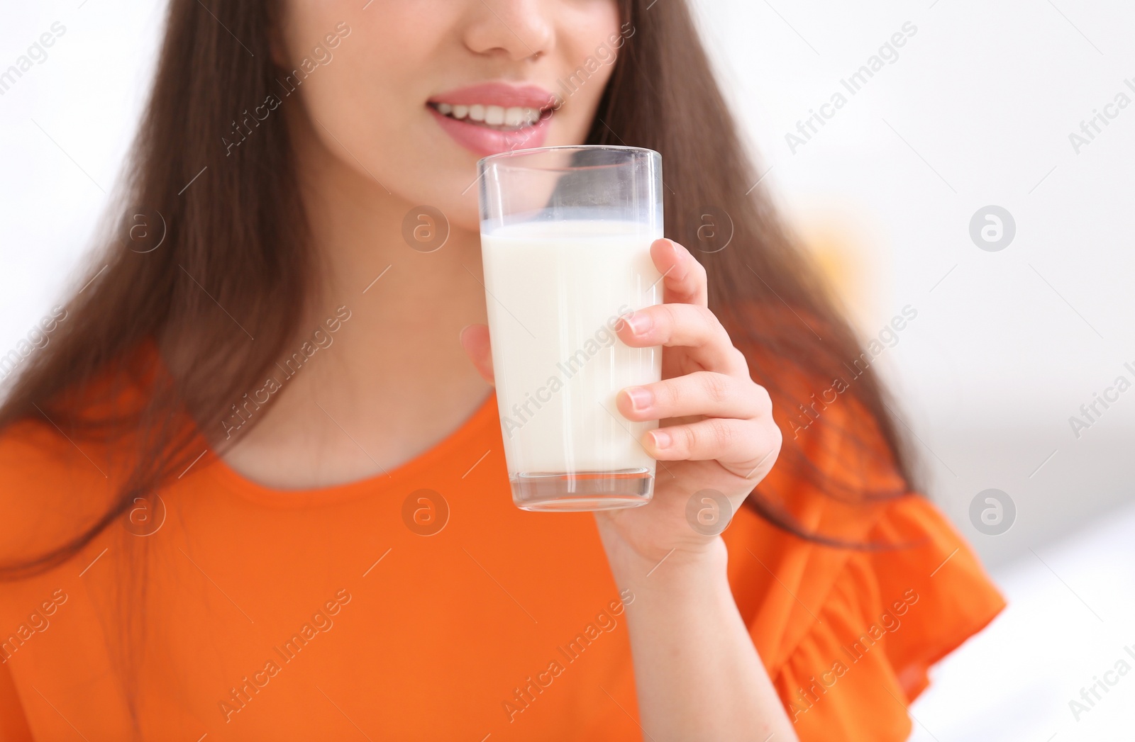 Photo of Beautiful young woman drinking milk, closeup