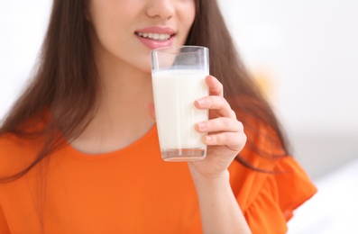 Beautiful young woman drinking milk, closeup