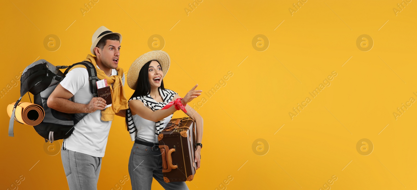 Photo of Emotional tourists with backpack and suitcase on yellow background