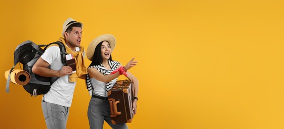 Photo of Emotional tourists with backpack and suitcase on yellow background