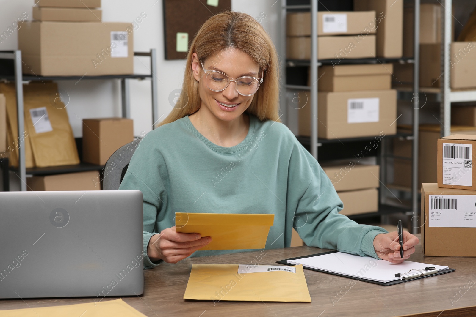 Photo of Seller with parcels working in office. Online store