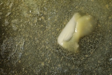 Photo of Tasty melting butter, top view. Space for text