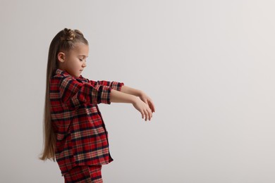 Girl in pajamas sleepwalking on white background, space for text