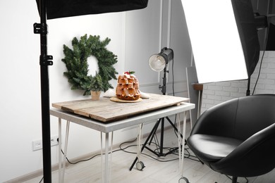Photo of Professional equipment and Christmas composition with Pandoro cake on wooden table in studio. Food photography