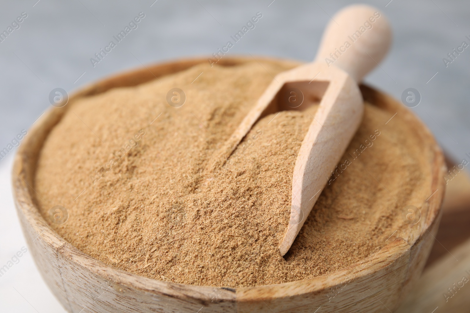 Photo of Dietary fiber. Psyllium husk powder in bowl and scoop on table, closeup