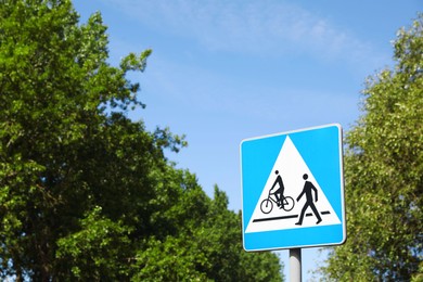 Photo of Road sign Pedestrian and Bicycle Crossings outdoors on sunny day. Space for text