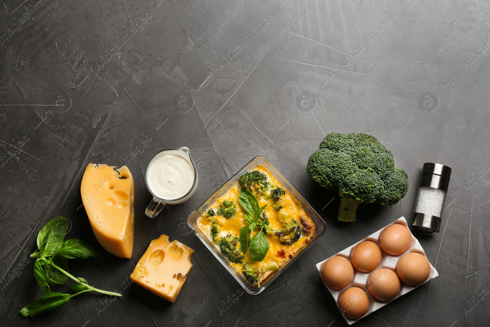 Photo of Flat lay composition with tasty broccoli casserole on grey table. Space for text