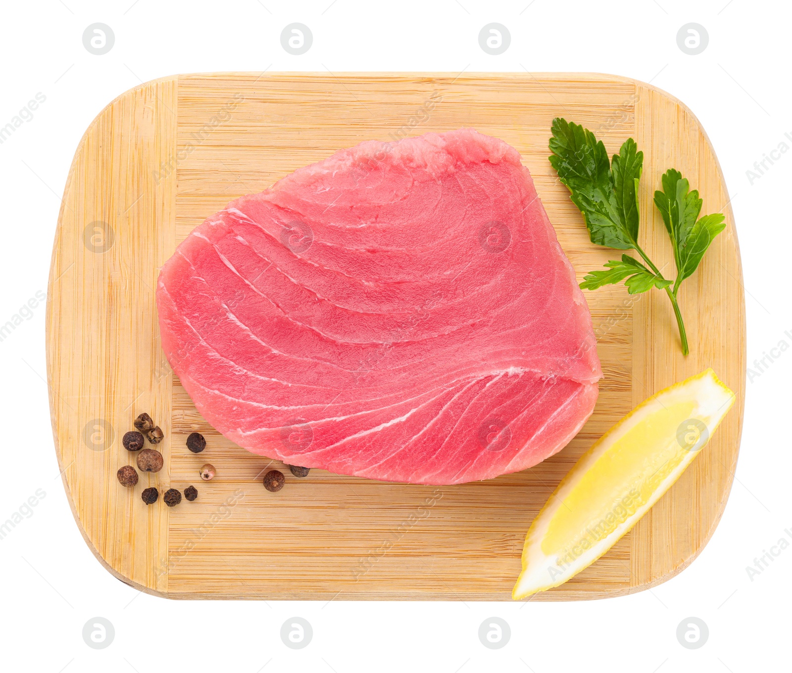 Photo of Raw tuna fillet, lemon wedge and parsley on white background, top view