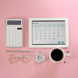 Modern tablet with calendar app on pink background, flat lay