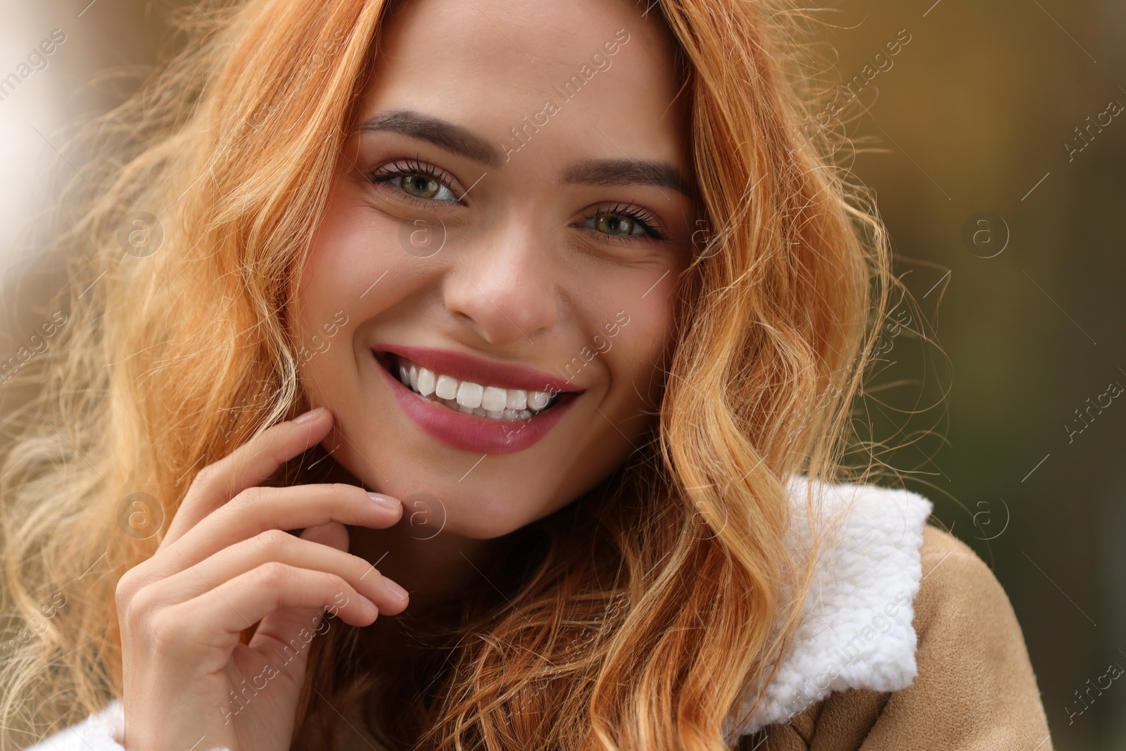 Photo of Autumn vibes. Portrait of smiling woman outdoors, closeup