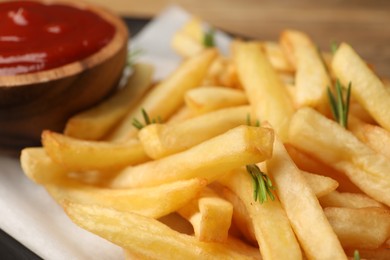 Delicious french fries served with ketchup on table, closeup