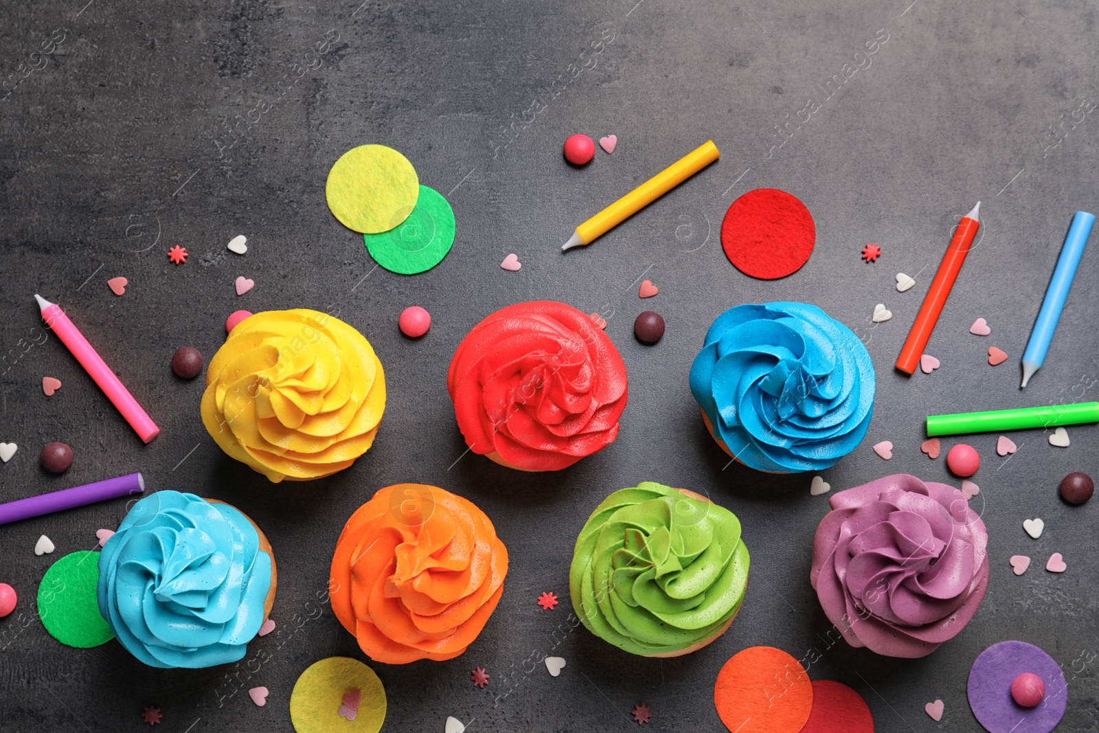 Photo of Delicious birthday cupcakes on gray background