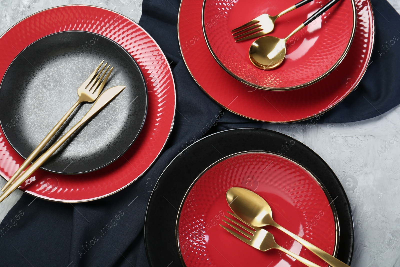 Photo of Stylish ceramic plates and cutlery on light table, flat lay