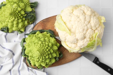Fresh Romanesco broccoli and cauliflower on white tiled table, flat lay