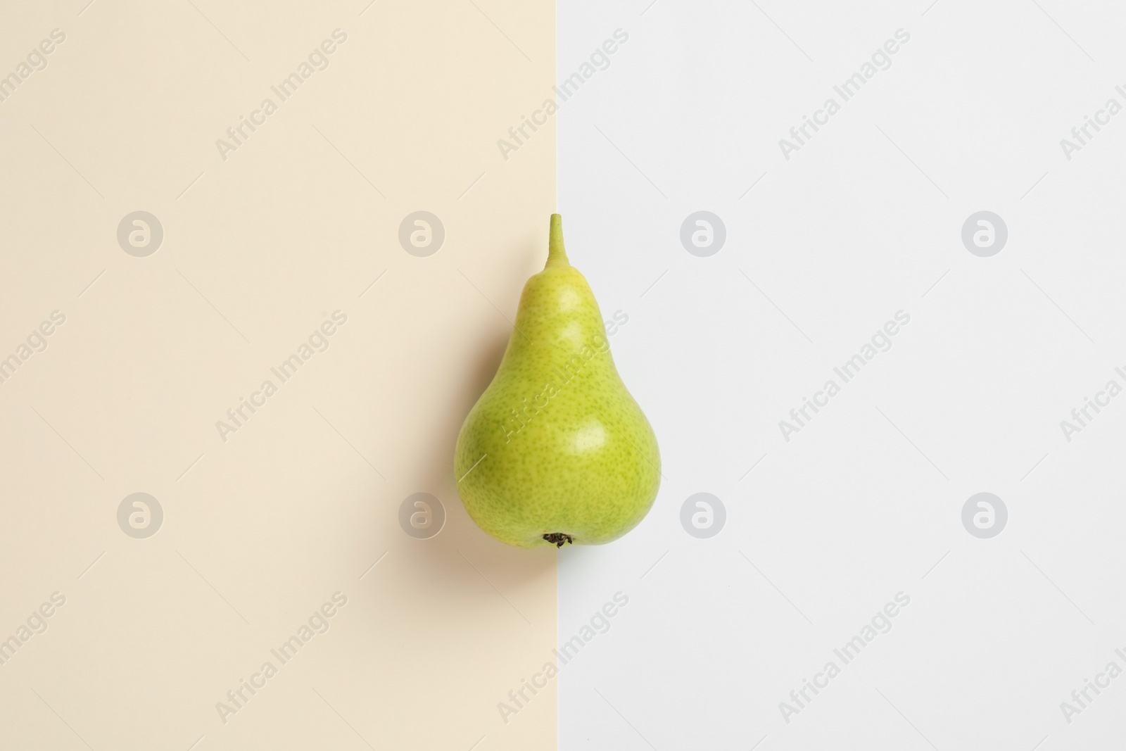 Photo of Ripe juicy pear on color background, top view