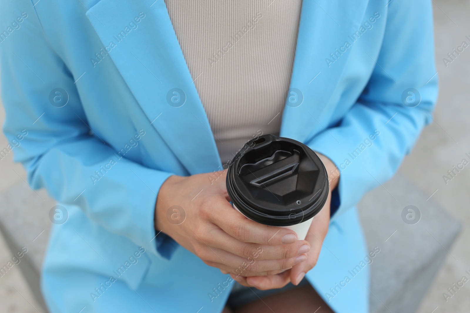 Photo of Coffee to go. Woman with paper cup of drink outdoors, closeup