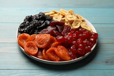 Photo of Delicious dried fruits on light blue wooden table