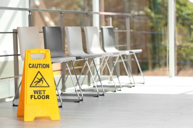 Safety sign with phrase Caution wet floor, indoors. Cleaning service