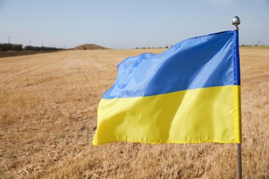 Photo of National flag of Ukraine in wheat field, closeup
