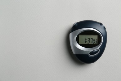 Digital timer on light grey background, top view. Space for text