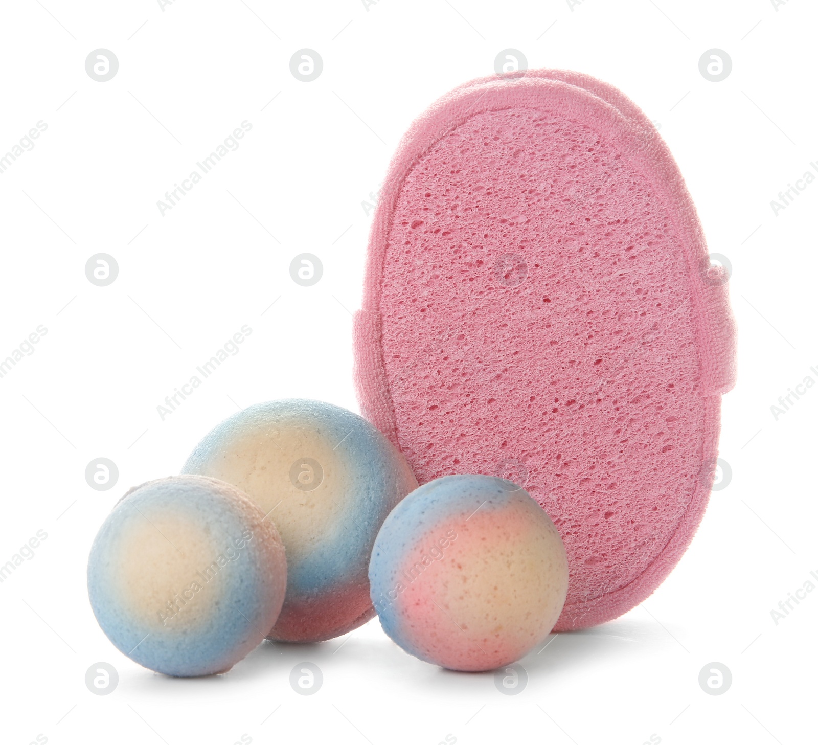 Photo of Pink sponge and bath bombs on white background