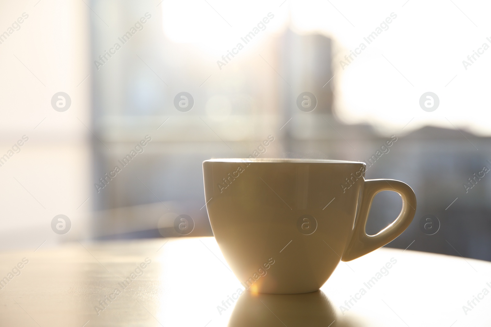 Photo of Cup of hot drink on table in morning. Space for text