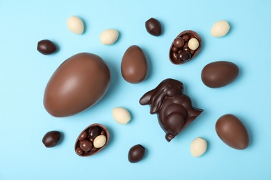 Photo of Flat lay composition with chocolate Easter eggs on color background