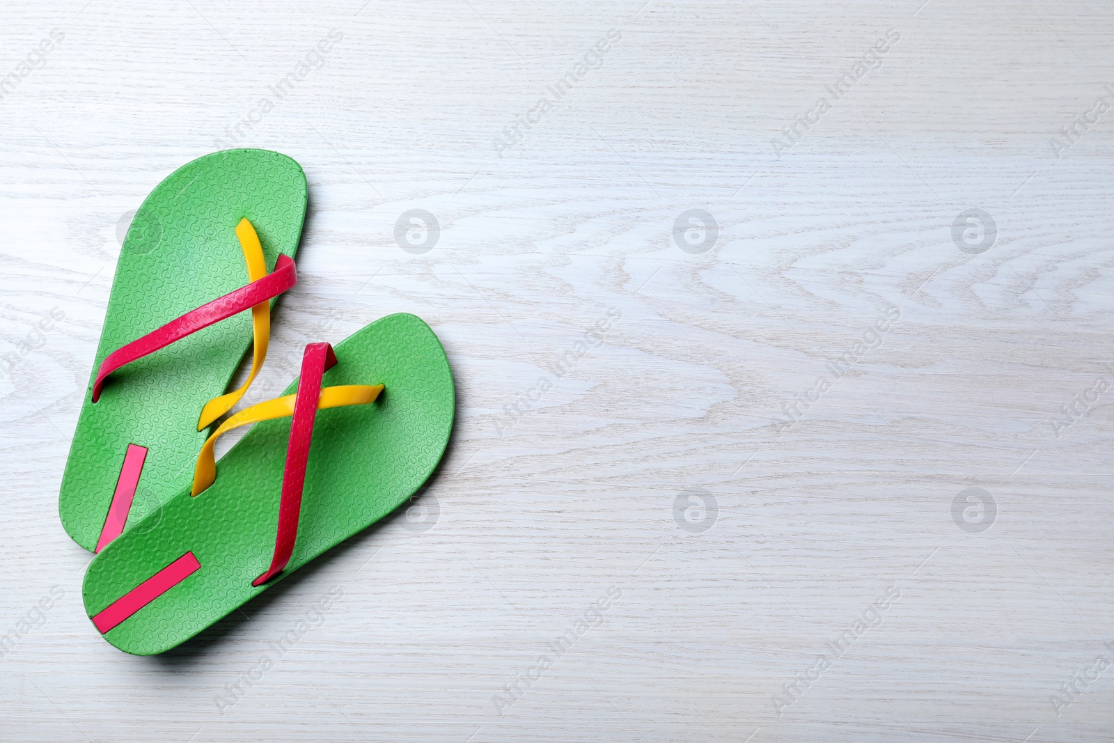 Photo of Stylish flip flops on white wooden background, flat lay. Space for text