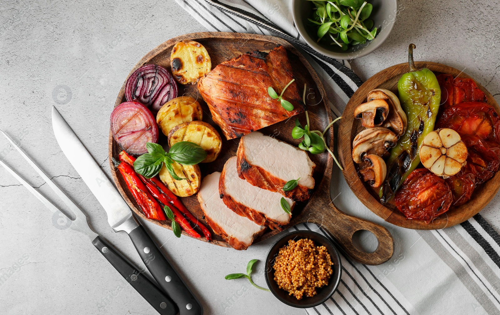 Photo of Delicious grilled meat and vegetables served on light grey table, flat lay