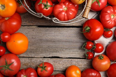 Frame of different ripe tomatoes on wooden table, flat lay. Space for text