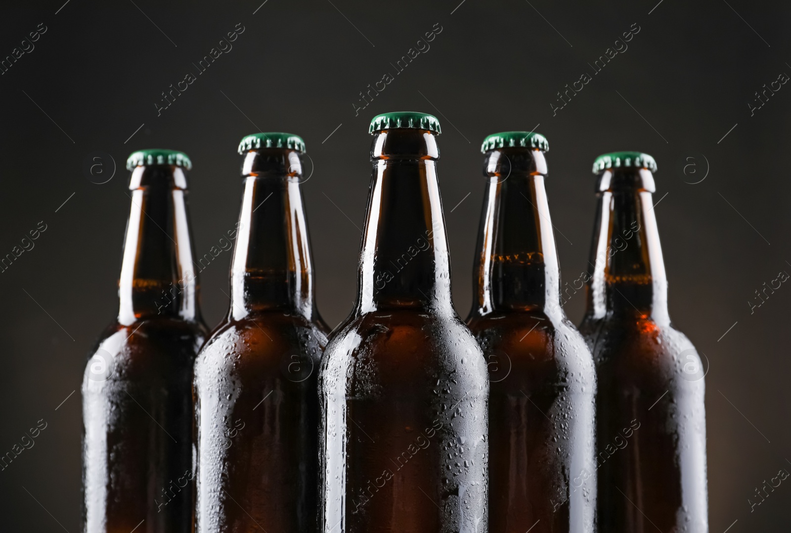 Photo of Many bottles of beer on dark background, closeup