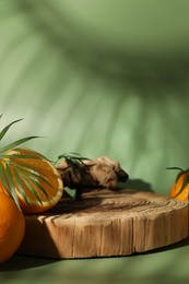 Photo of Tasty fresh oranges and leaves on green background, closeup. Space for text