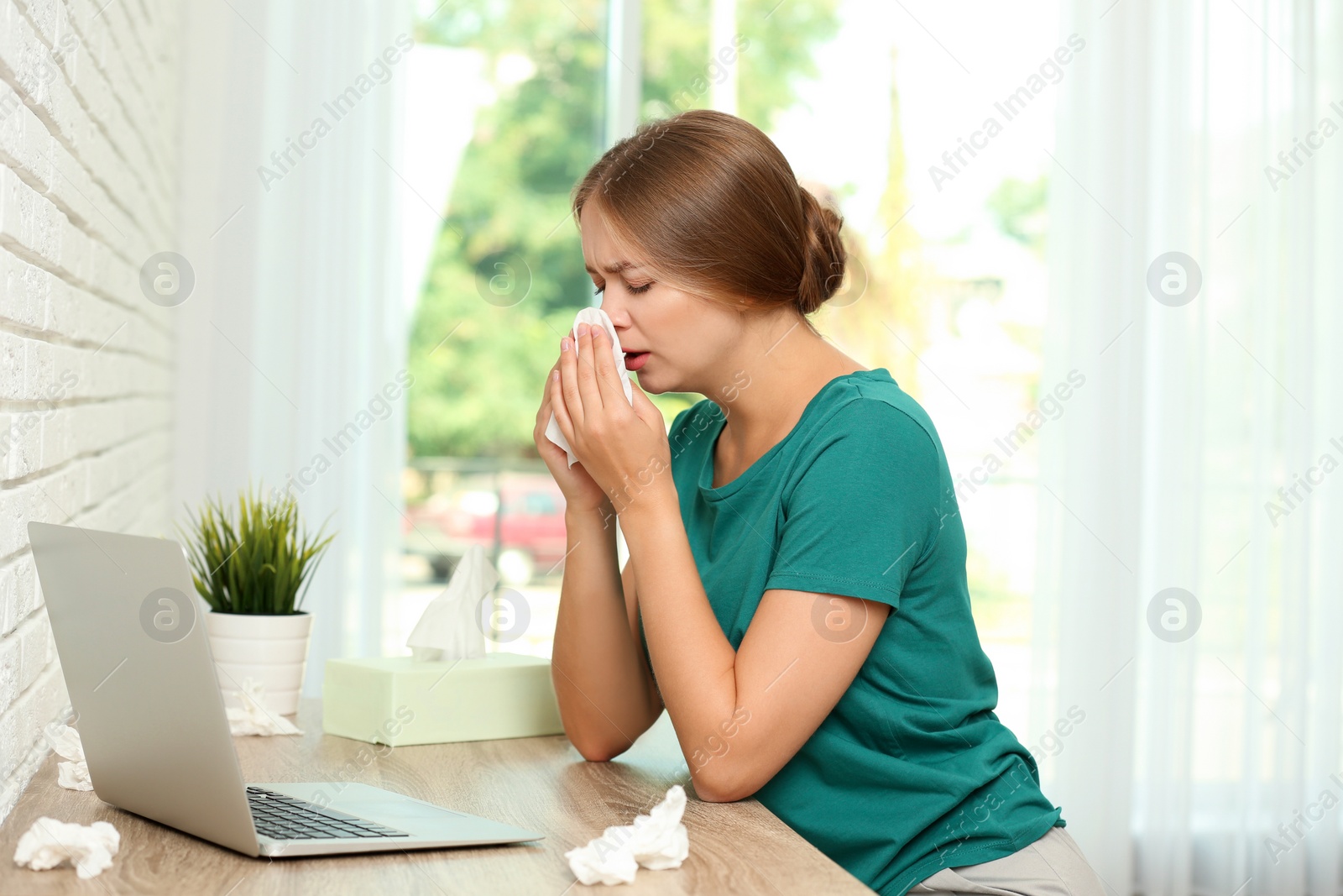 Photo of Young woman suffering from allergy at home office