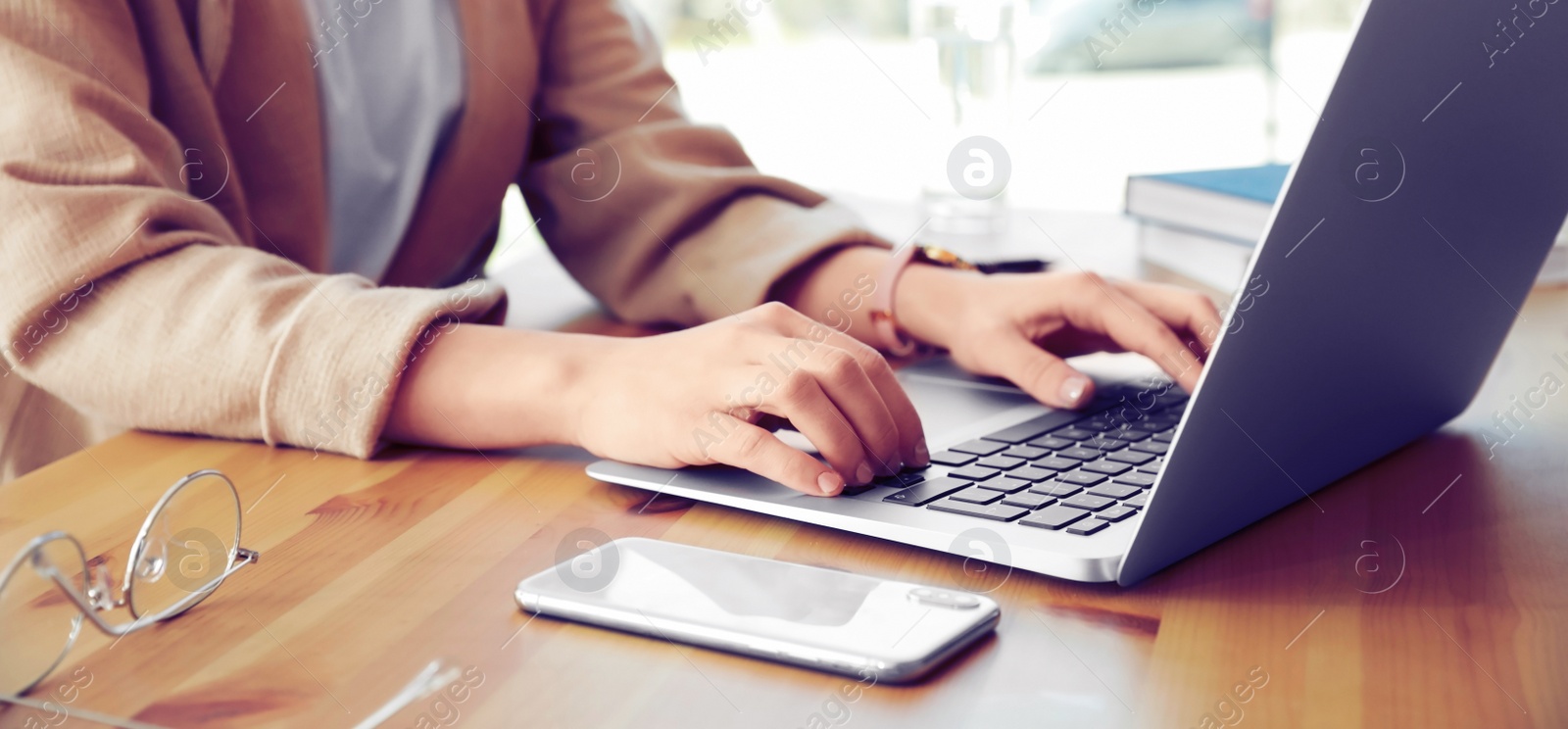 Image of Young woman working on computer at table in office, closeup. Banner design